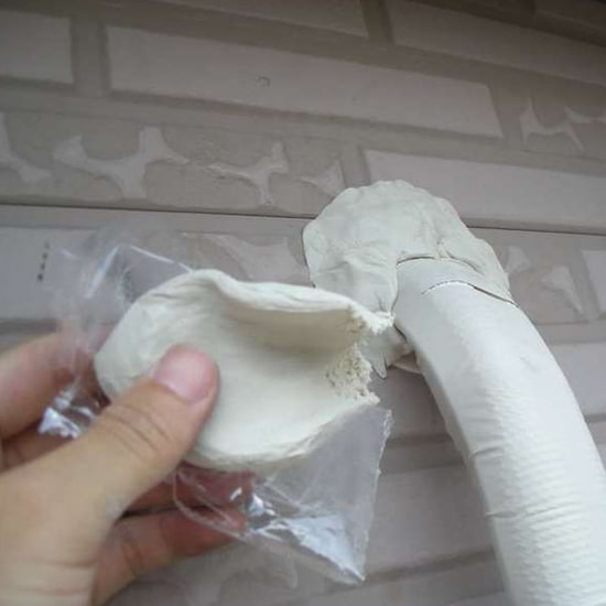 Representative HVAC wall penetration sealing putty in use around a line set